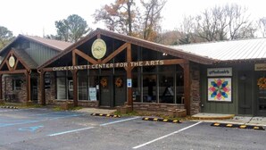 The exterior of the Chuck Sennett Center for the Arts, featuring a brick facade, large windows, and a parking lot. - Cabin in the Woods | Hot Tub, Fire Pit, BBQ (Mentone)