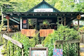 Un espacio de estar rústico al aire libre con un letrero que dice “Wildflower” y una valla de madera.