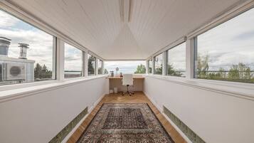 Enjoy expansive views of the surrounding landscape from the large windows in this stylish room.