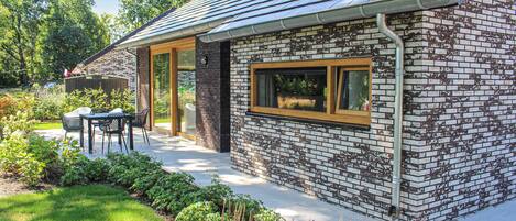 A modern house with a brick exterior, a wooden door, and a window with a wooden frame.