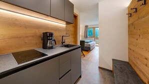 Une cuisine moderne équipée d’une cuisinière intégrée, d’une machine à café et d’un évier.
