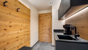 Une cuisine moderne avec un mur en bois, un évier et une machine à café.