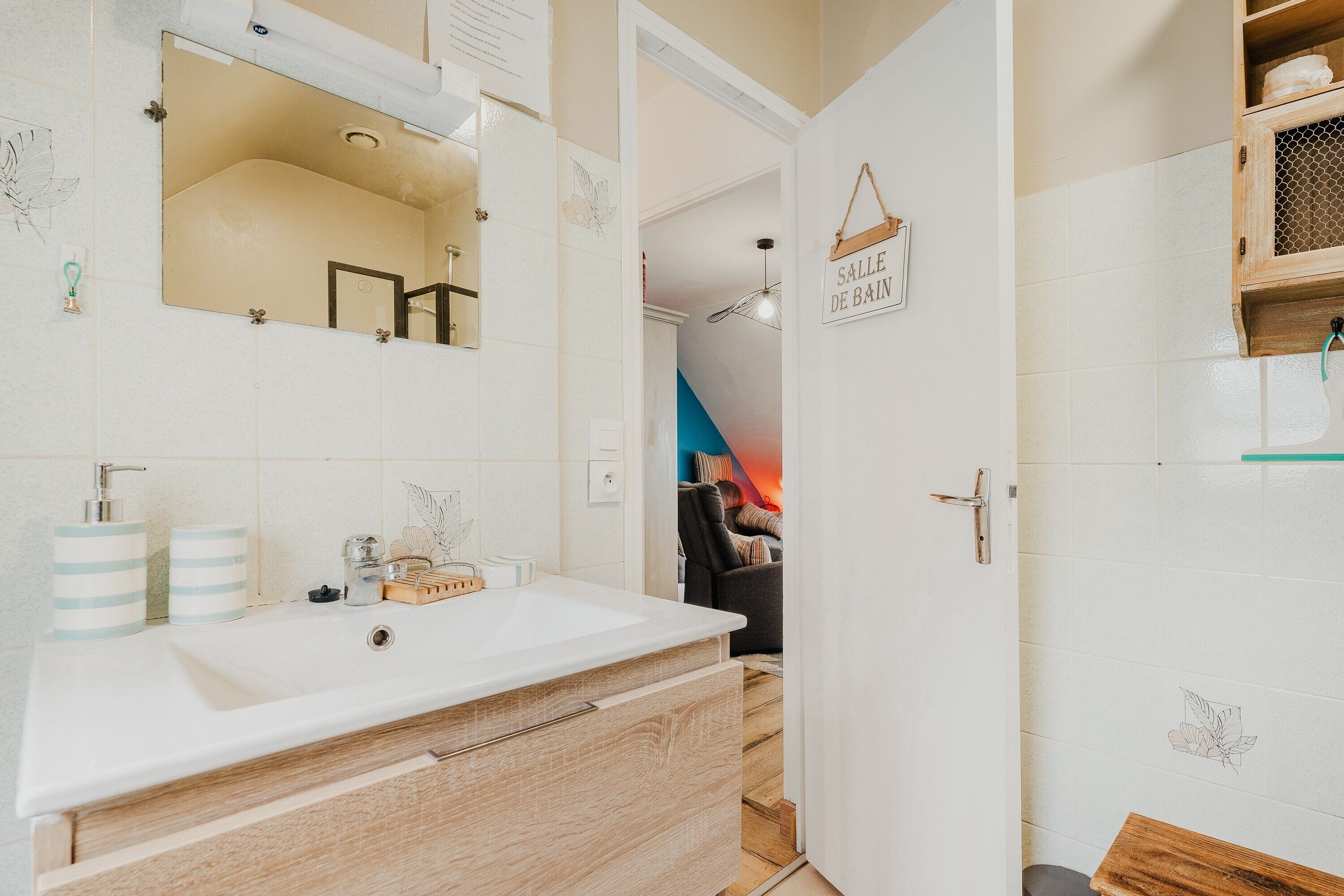 Ein Badezimmer mit Waschbecken, Spiegel und Handtuchhalter.