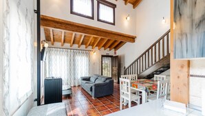 Un vaste espace de vie comprenant un canapé, une table et un escalier.