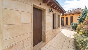 Un bâtiment doté d’un trottoir carrelé, d’une porte en bois et du chiffre « 3 » au-dessus.
