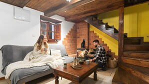 Ein gemütliches Wohnzimmer mit einer Couch, einem Couchtisch, einem Kamin und einer Treppe.
