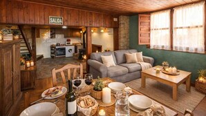 A cozy interior with a dining area, a sofa, a kitchen in the background, and a sign reading 'SALIDA'. - Montegrande Apartment Surrounded by Mountains with Shared Terrace and Wi-Fi (La Villa de Sub)