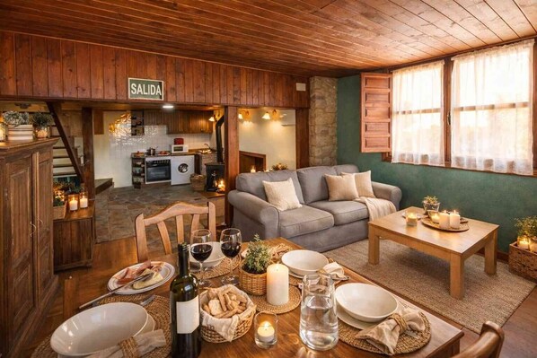 A cozy interior with a dining area, a sofa, a kitchen in the background, and a sign reading 'SALIDA'. - Montegrande Apartment Surrounded by Mountains with Shared Terrace and Wi-Fi (La Villa de Sub)