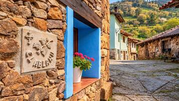 A stone building with a blue window sill and a potted plant.