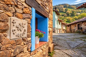 A stone building with a blue window sill and a potted plant. - Apartment 'El Ablanu, Hot Tub & Mountain Views' with Terrace and Wi-Fi (Proaza)