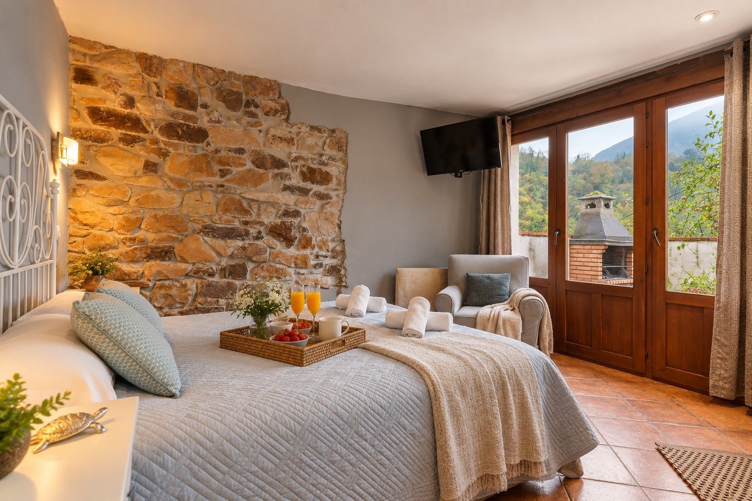 Ein Schlafzimmer mit Stehwänden, einem Bett mit Obst- und Getränkeauswahl, einem Fernseher und Blick ins Freie.