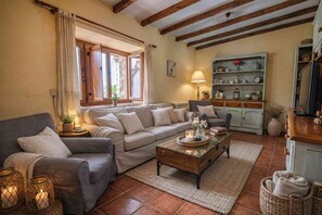 Una sala de estar acogedora con un sofá, una mesita de centro y un aparador.