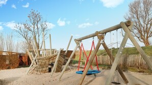 Un patio de juegos con columpios y una estructura para escalar.