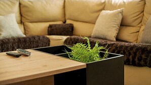 Ein Wohnzimmer mit einer Couch, einem Couchtisch und einer Pflanze in einem Topf.