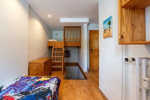 A bedroom with a bunk bed, wooden furniture, a ladder, a radiator, and a painting on the wall. - Apartment 'Shamrock 2B' with Mountain View, Balcony and Wi-Fi (Tignes)