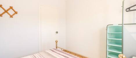 Un dormitorio con cama, armario y puerta.