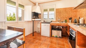 Una cocina con estufa, fregadero y lavavajillas.