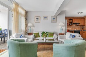 A living room with a sofa set, a coffee table, and a potted plant.