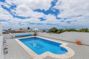 Una piscina en la azotea con vistas despejadas de los edificios y el cielo circundantes.