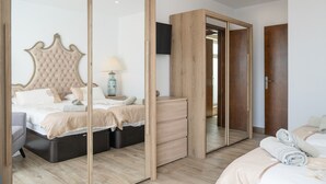 Un dormitorio con una cama grande, un aparador, un espejo y un armario.