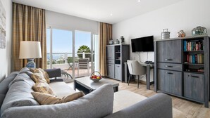 Una sala de estar moderna con un sofá, una mesa de centro, un televisor y una estantería.
