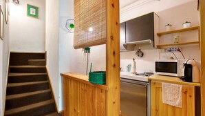 Une cuisine équipée d’un four à micro-ondes, d’une cuisinière et de meubles de rangement en bois.