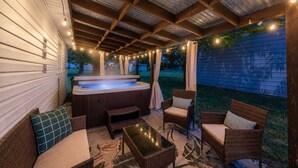 An outdoor patio with a hot tub, wicker furniture, string lights, and a covered ceiling. - Hot Tub - Shuffleboard - Sleeps 8 - Near Cleveland (Parma Heights)