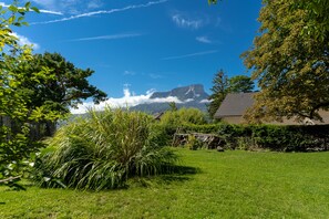 A grassy yard with a house, trees, and a mountain in the background. - Gite De Myans for 15 with Garden, Mountain Views, Private Terrace, BBQ & Wi-Fi (Myans)
