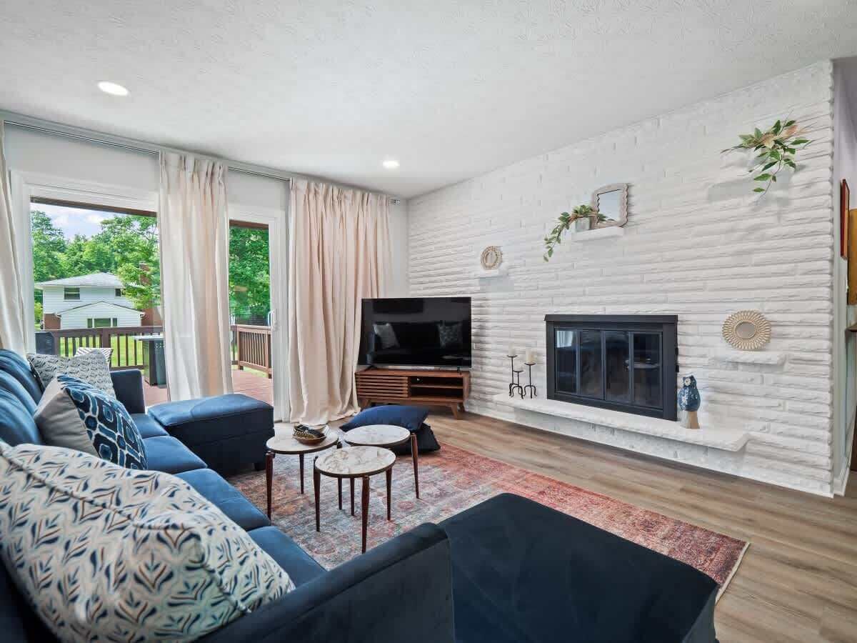 A modern living room with a TV, sofa, and fireplace.