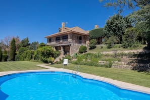 A large stone house with a swimming pool, surrounded by well-maintained lawns and trees. - Las Yernas: Rural House in Sierra de Gredos with Private Pool for Groups (La Serrada)