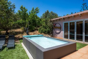 A rectangular swimming pool with a built-in hot tub, surrounded by artificial grass, and a patio area with lounge chairs. - Holiday Home 'Aires Del Tomir' with Private Pool, Shared Terrace and Wi-Fi (Inca)