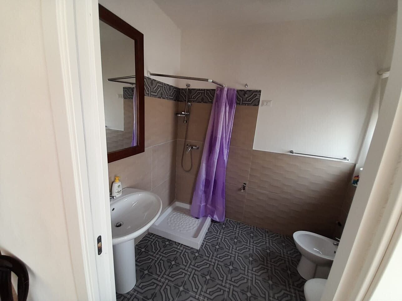 Ein Badezimmer mit Dusche, Toilette und Waschbecken.