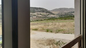 A view through a window of a landscape with hills, a bridge, and a vineyard. - Room 'Vista Montagna 2' with Shared Terrace, Wi-Fi and Air Conditioning (Siculiana)