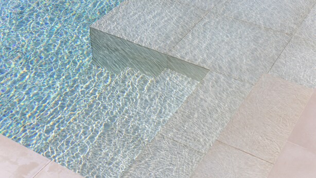 A pool with clear water and tiled edges.
