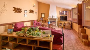 Una sala de estar acogedora con chimenea, muebles de madera y un comedor.