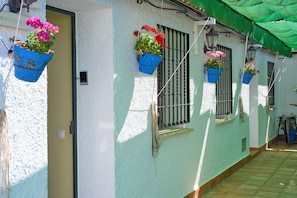 A building with white walls, a green awning, and hanging flower pots. - Rivero Rural Country House - Private and Indoor Pool, 10 Bedrooms, 22 Guests (Rivero de Posadas)