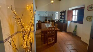 An interior with a dining area, kitchen, and a decorative tree with lights.