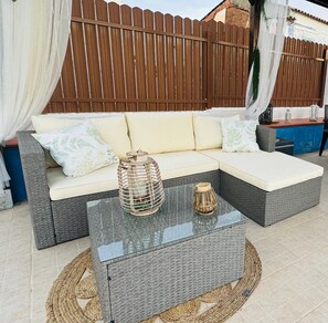 A sectional sofa with cushions, a glass-top coffee table, and a wicker basket. - Villa 'Casa D’ Avó Lita' with Private Pool, Private Terrace and Wi-Fi (Falcoeiras)