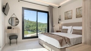 Ein modernes Schlafzimmer mit einem großen Bett, einem Schreibtisch, einem Stuhl, einem Spiegel und Kunstwerken an den Wänden.