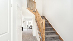 A staircase with wooden balusters and carpeted steps leading to a landing. - Chic Retreat Near Niagara Falls (Niagara Falls)