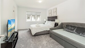 A bedroom with a bed, a sofa, a TV, and a window. - Chic Retreat Near Niagara Falls (Niagara Falls)