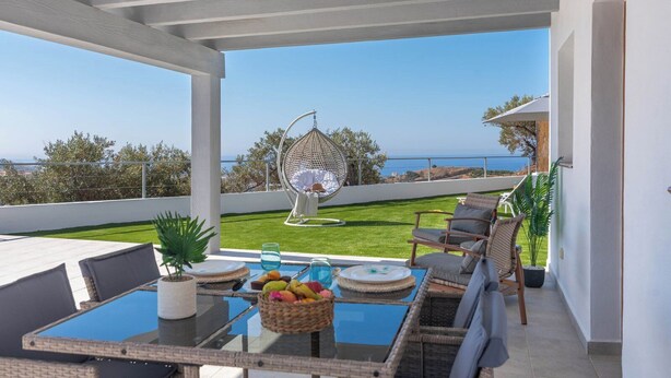 Terraza con mesa de billar, asientos y una silla colgante con vistas panorámicas.
