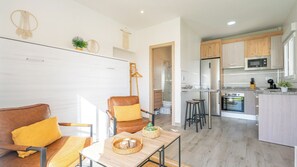 Una cocina moderna con una isla central, armarios de madera y electrodomésticos de acero inoxidable.