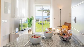 Una cocina moderna con encimeras de granito, dos tazones de cereal con frambuesas y una cesta de pan.