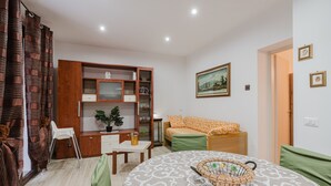 Un dormitorio con una cama, un armario de madera, un escritorio, una silla y un cuadro en la pared.