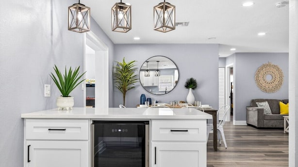 A modern kitchen with white cabinetry, a built-in dishwasher, and pendant lighting. - Family Pool Home | Game Room + Fire Pit | Largo (Largo)
