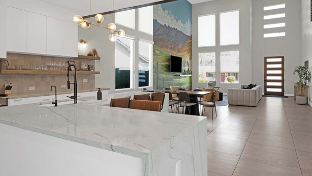 A spacious kitchen with a marble island, modern lighting, and a large window overlooking a mountainous landscape. - Heated Pool & Spa, Golf Simulator, Billiards (Scottsdale)