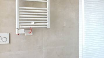 Ein modernes Badezimmer mit integriertem Bidet, Handtuchhalter und Dusche.