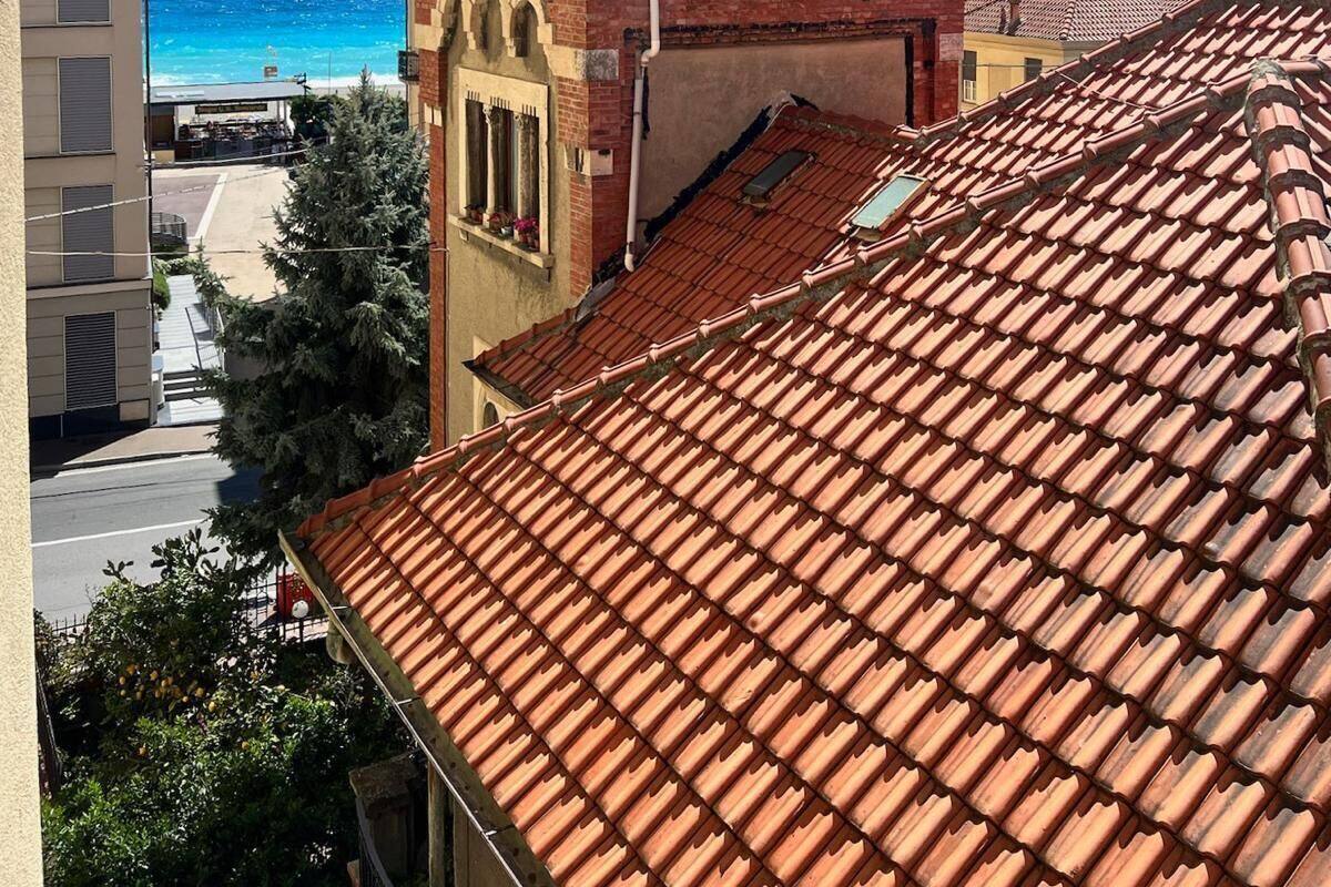 A building with a red-tiled roof and a brick tower with arched windows.