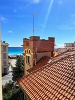 Un edificio con tetto in tegole rosse e una torre in mattoni con finestre ad arco.